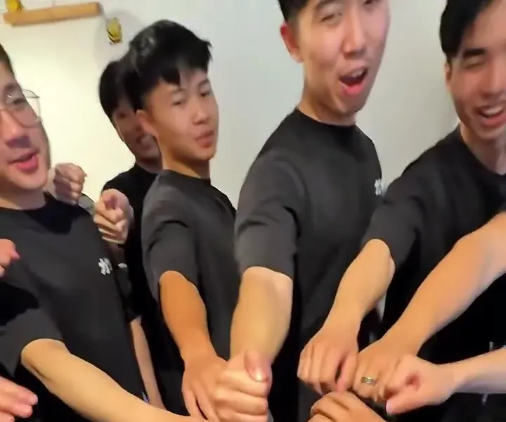 The Katsu crew in their black tees, hands in together